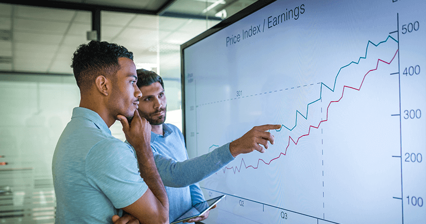 Two people looking at a graph indicating earnings gained through digital signage integrators