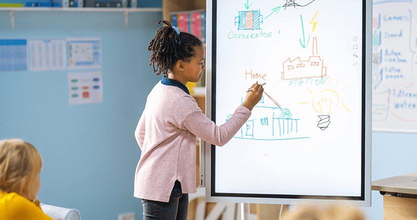 a little girl drawing on an interactive screen