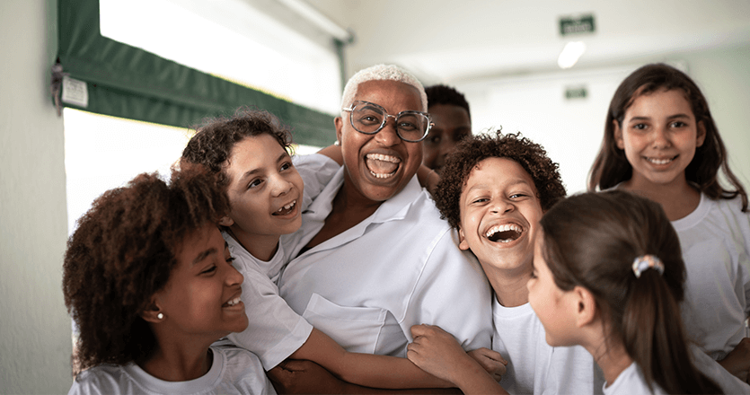 a teacher is embraced by her young students