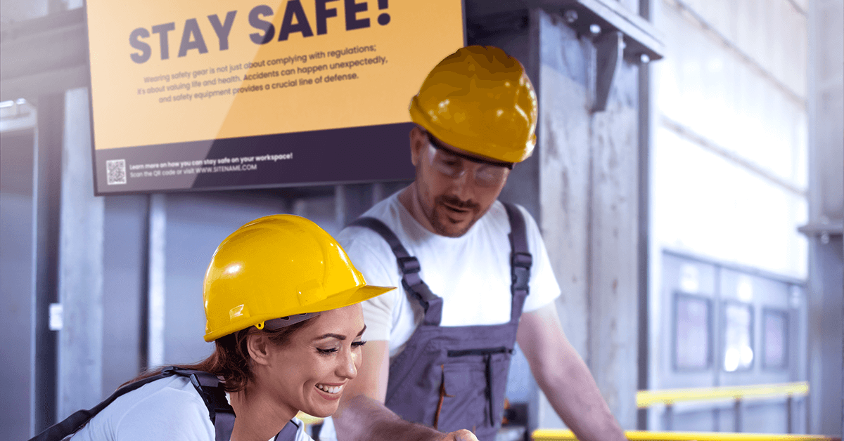 People working in manufacturing environment with a digital sign behind them featuring a safety quote