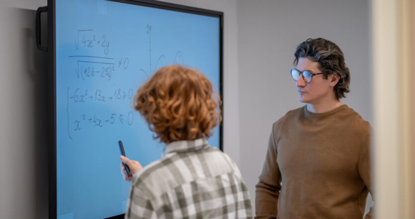 Education Interactive digital signage board. A teacher and a student in a classroom.